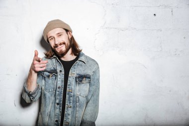 Poz ve işaret neşeli sakallı hippi adam.