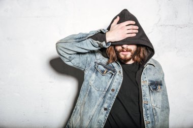 Yakışıklı sakallı hippi adam duvar arka plan üzerinde poz.