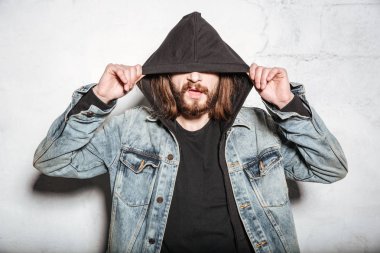 Genç çekici sakallı hippi adam duvar arka plan üzerinde poz.