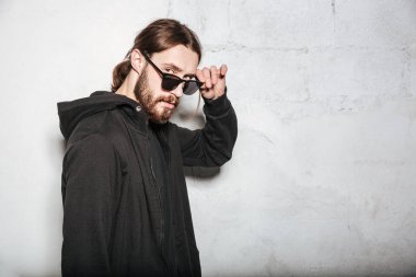 Yakışıklı sakallı hippi adam duvar arka plan üzerinde poz.