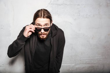 Genç yakışıklı hipster adam duvar arka plan üzerinde sakallı..