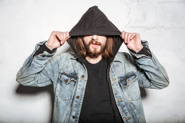 Genç çekici sakallı hippi adam duvar arka plan üzerinde poz.