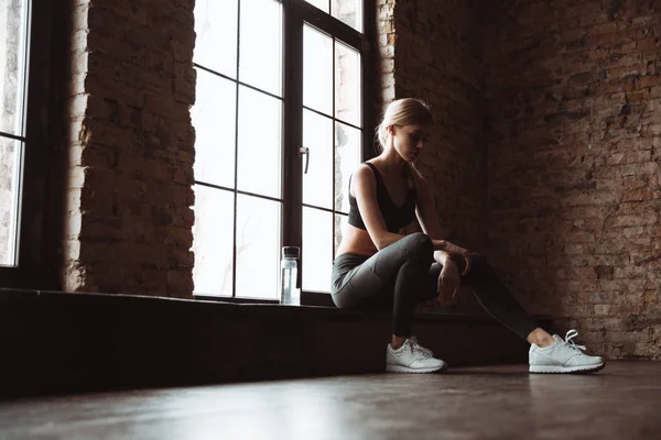 Hübsche junge Fitness-Frau sitzt im Fitnessstudio — Stockfoto