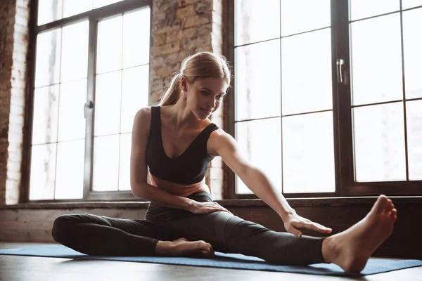 Underbara unga fitness kvinna göra stretchingövningar. — Stockfoto