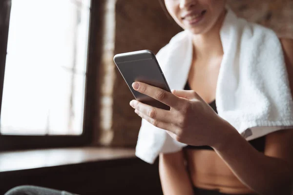 Bijgesneden afbeelding van jonge fitness vrouw chatten via de telefoon. — Stockfoto