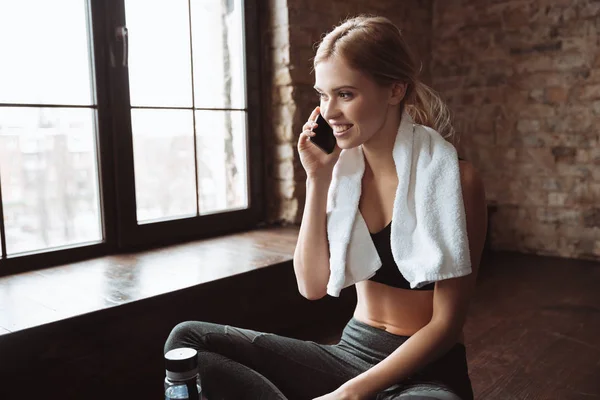 Joven mujer fitness con toalla hablando por su teléfono . —  Fotos de Stock