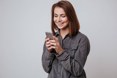 Cep telefonu kullaranarak mutlu genç bayan.