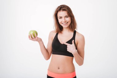 Elma tutan ve işaret neşeli genç fitness Bayan