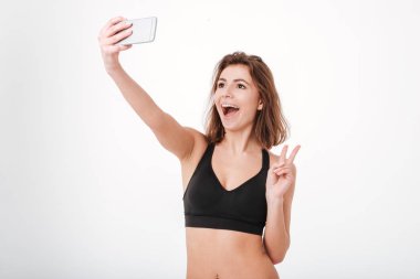 Barış işareti ve alma selfie smartphone ile gösterilen fitness kadın