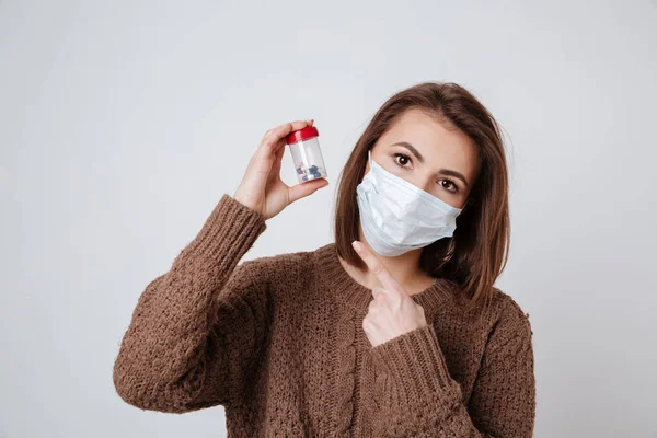 Woman in sweater and medical mask holding tablets — Stock Photo, Image