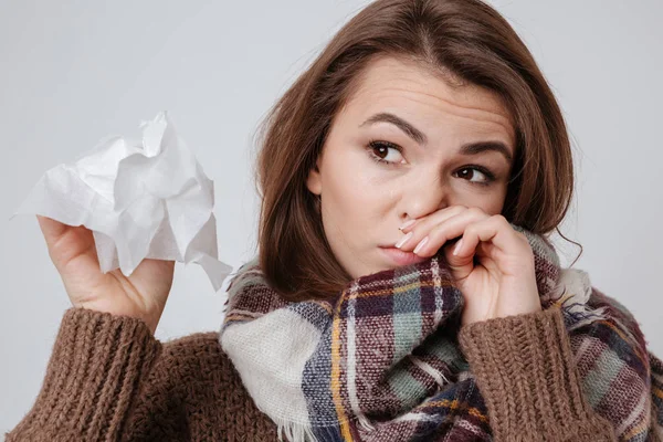 Sick young lady with napkin over gray background. — Stock Photo, Image