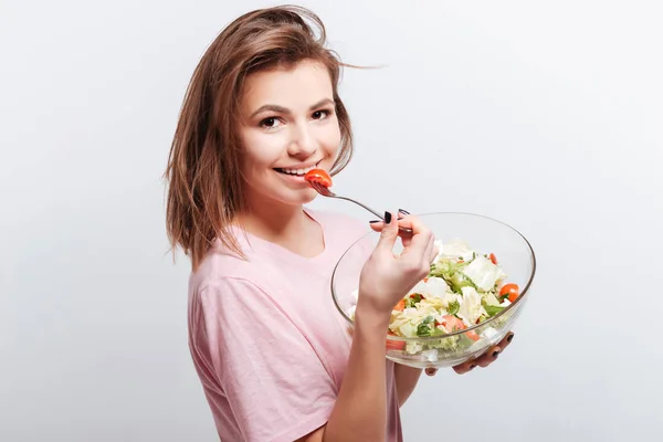 Jovem atraente comendo salada — Fotografia de Stock