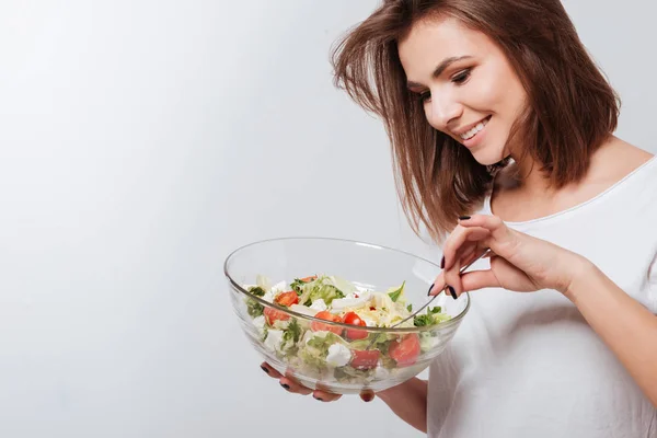 Bella giovane signora mangiare insalata — Foto Stock