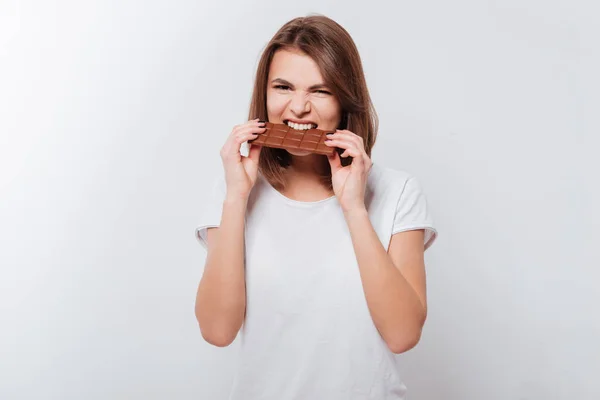 Fome jovem mulher comendo chocolate — Fotografia de Stock