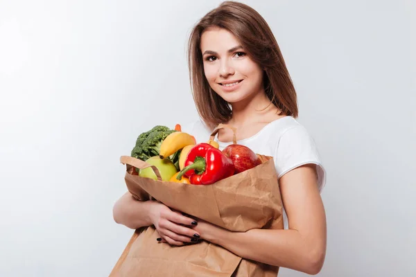 Jovencita alegre sosteniendo frutas y verduras —  Fotos de Stock