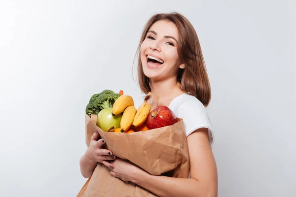 Giovane donna allegra che tiene frutta e verdura — Foto Stock