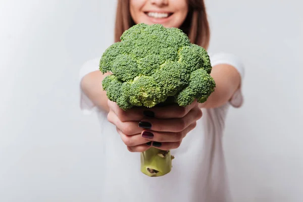 Genç kadın gösteren brokoli kamera için. — Stok fotoğraf