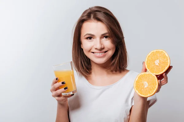 Atractiva joven dama sosteniendo naranja y jugo — Foto de Stock