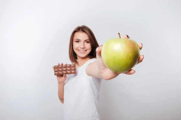 微笑的年轻女士控股苹果和巧克力 — 图库照片