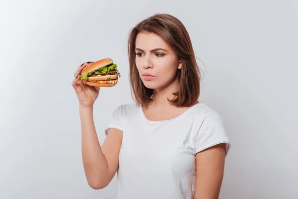 Confused hungry woman eating fastfood — Stock Photo, Image