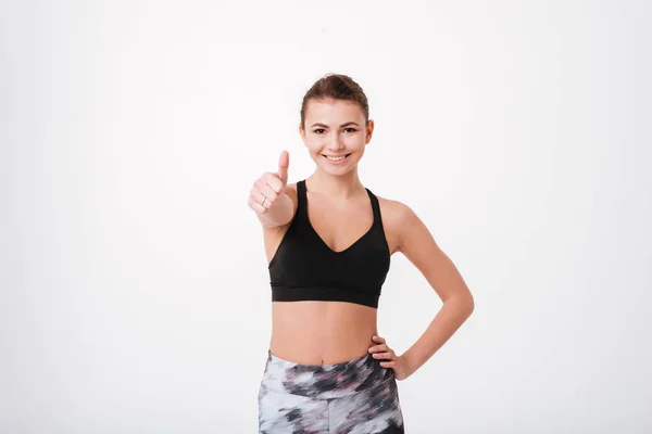 Aantrekkelijke jonge fitness dame duimschroef opwaarts gebaar maken — Stockfoto