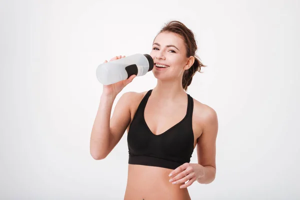 Sportliche junge Frau trinkt Wasser — Stockfoto