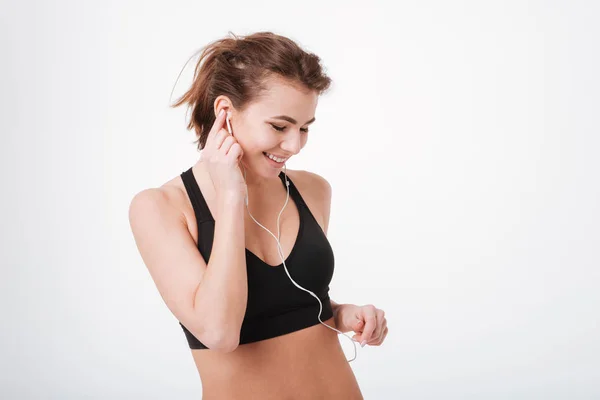 Joven mujer fitness escuchando música con auriculares —  Fotos de Stock