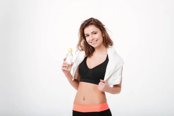 Glad ung fitness kvinna med handduk och vattenflaska — Stockfoto