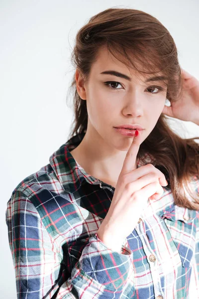 Atractiva mujer joven en camisa a cuadros que muestra señal de silencio —  Fotos de Stock
