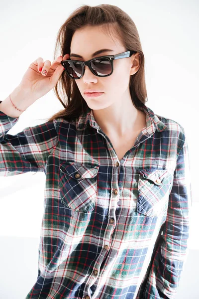 Portret van mooie jonge vrouw in plaid shirt en zonnebril — Stockfoto