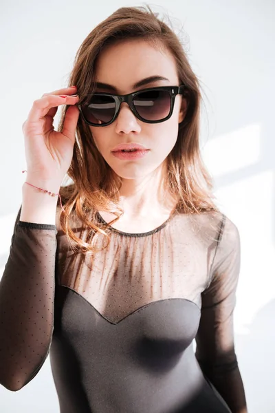 Junge schöne Dame mit Sonnenbrille steht im Studio — Stockfoto