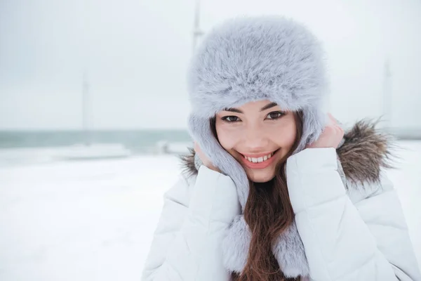 Felice giovane donna che indossa cappello a piedi vicino alla spiaggia — Foto Stock