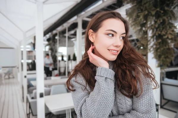 Bonita joven vestida con suéter sentada en la cafetería — Foto de Stock
