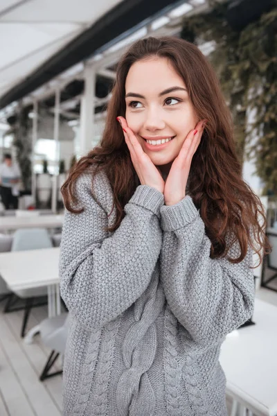 Χαριτωμένο νεαρή κοπέλα ντυμένη στα πουλόβερ που κάθεται στο καφενείο — Φωτογραφία Αρχείου