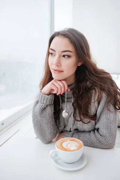 Dość młoda kobieta ubrana w swetrze, siedząc w kawiarni — Zdjęcie stockowe