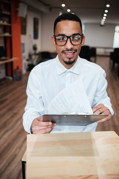 Attractive african businessman looking at notepad. Coworking. — Stock Photo, Image