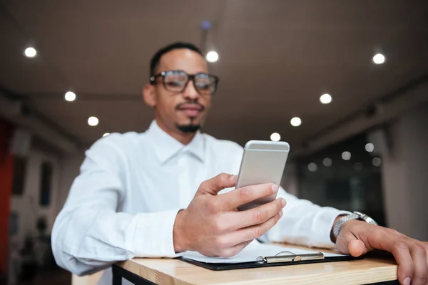 Attractive african businessman chatting by phone. Coworking. — Stock Photo, Image