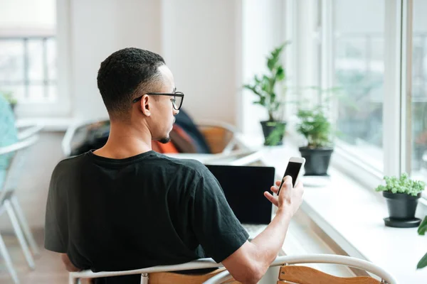 Rückansicht einer jungen afrikanischen Studentin mit Handy — Stockfoto