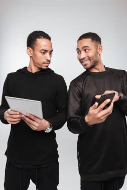 Mutlu Afrika erkekler telefon ve tablet bilgisayar kullanarak.