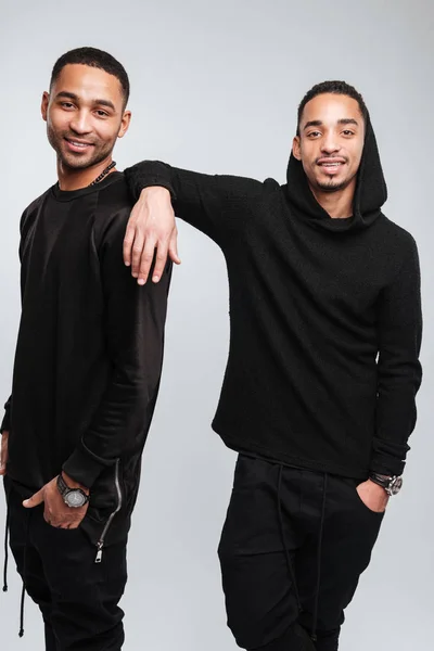 Zwei glückliche attraktive afrikanisch-amerikanische junge Männer in schwarzen Kleidern — Stockfoto