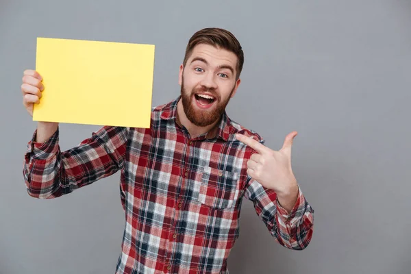 Счастливый молодой бородатый мужчина держит копирайт пустым — стоковое фото