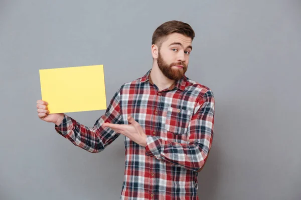 Attractive young bearded man holding copyspace blank — Stock Photo, Image