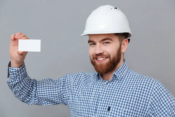 Щасливий бородатий будівельник тримає візитку з копійкою — стокове фото
