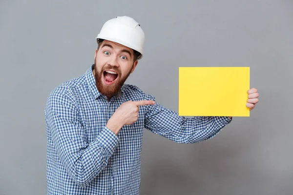 Привабливий молодий бородатий чоловік будівельник тримає копійс порожній — стокове фото