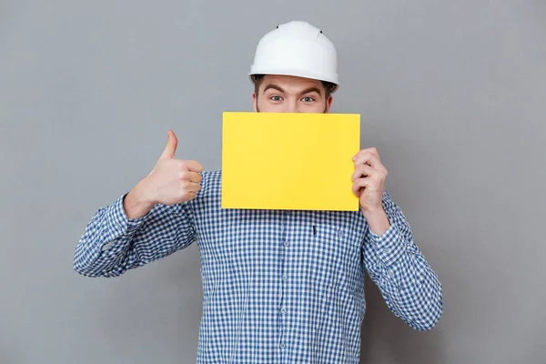 Constructor sosteniendo espacio de copia en blanco hacer pulgares gesto hacia arriba —  Fotos de Stock