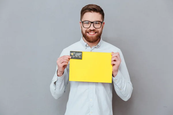 Hombre de negocios guapo sosteniendo espacio de copia en blanco y tarjeta de débito —  Fotos de Stock