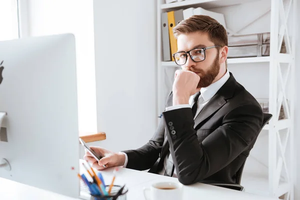 Geconcentreerde jonge bebaarde zakenman met behulp van computer — Stockfoto