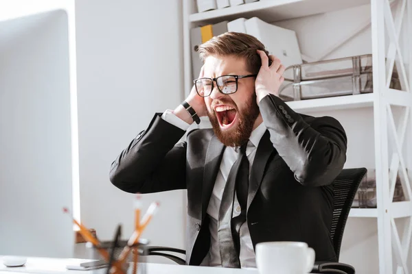 Gritando hombre de negocios barbudo sentado en la oficina —  Fotos de Stock