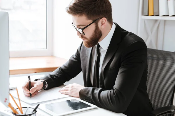 Knappe zakenman schrijven notities. — Stockfoto