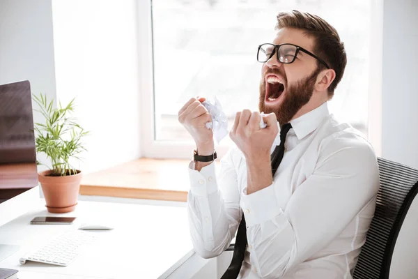 Кричащий злой бизнесмен сидит в офисе — стоковое фото